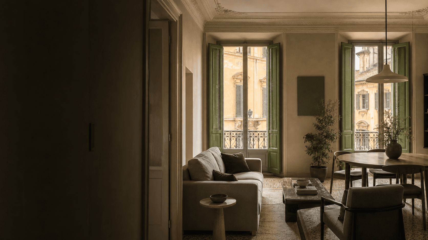 Soggiorno elegante in un palazzo storico italiano, con persiane verdi aperte su una facciata ocra e arredi curati